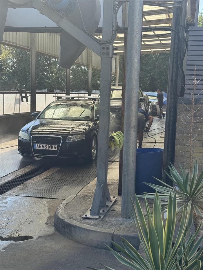 An Audi being pressure washed in the wash bay